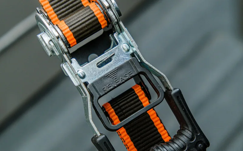 Close-up van de ratelsluiting van een oranje spanband